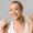 Orthodontic concept. Happy girl showing her beaming white teeth with two forefingers, grey background