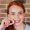 redhaired ginger female with snow-white smile holding white wisdom tooth after surgery removal of a tooth